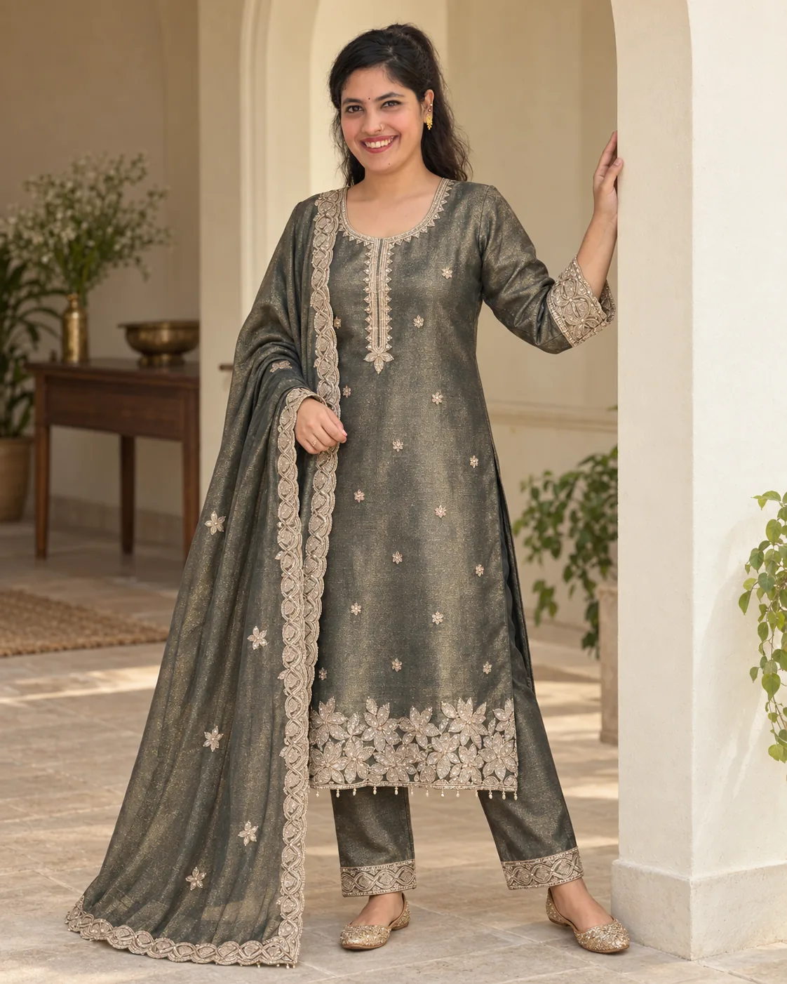 Model in a charcoal bronze shimmer suit with a gold leaf-and-flower hem and matching plain trousers
